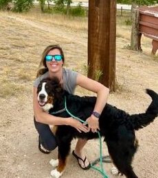 girl hugging a Bernese mountain dog outside