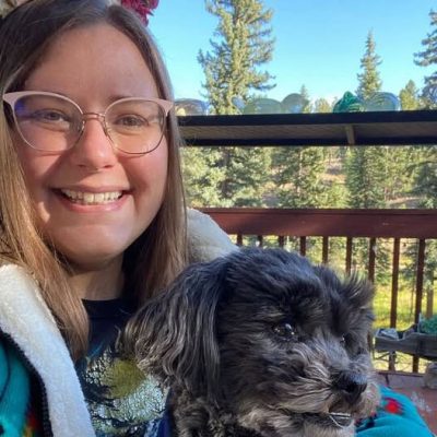 Erin smiling girl sitting on porch in nature holding small dog